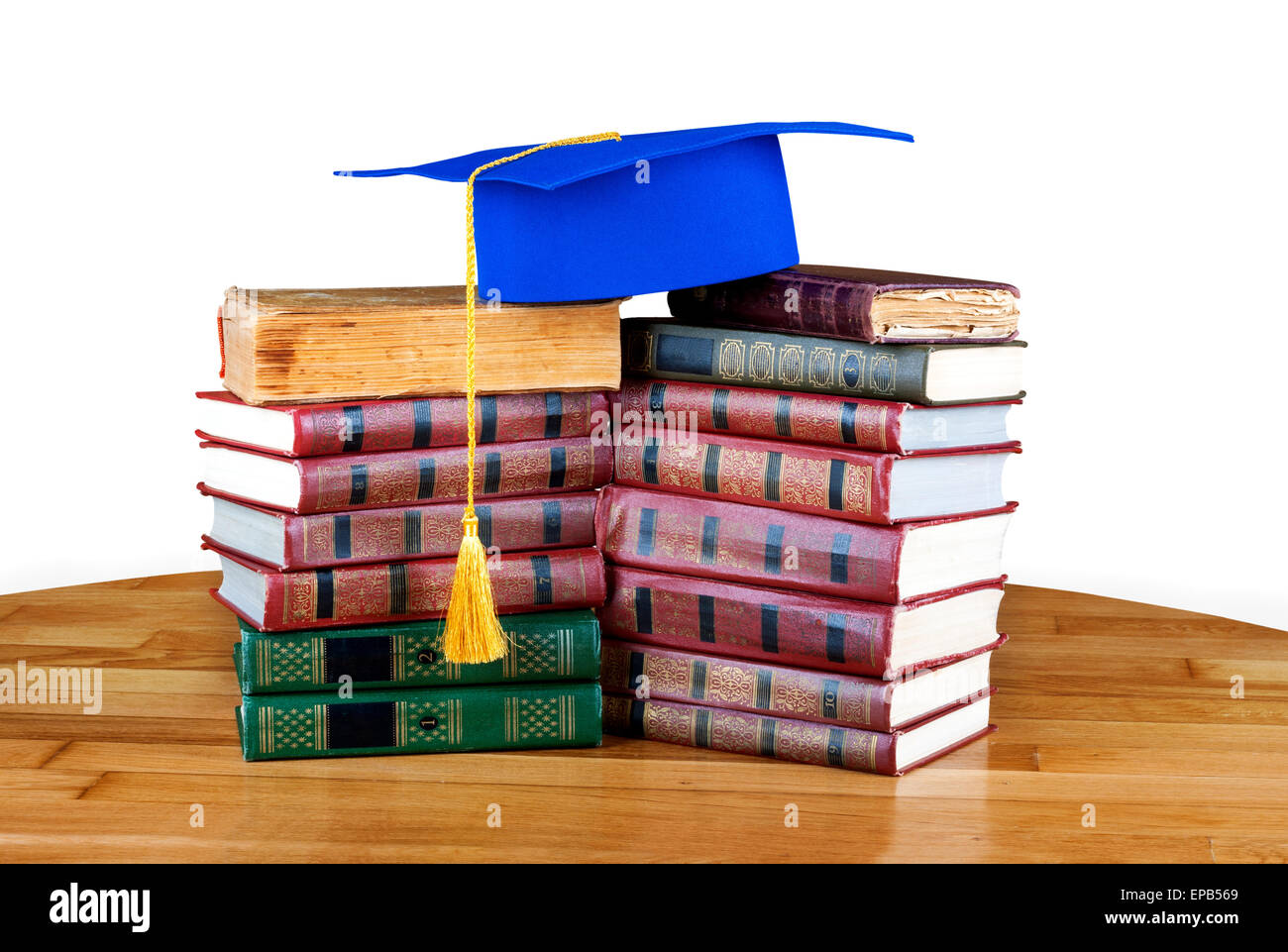 Graduation mortarboard on top of stack of books on white isolated ...