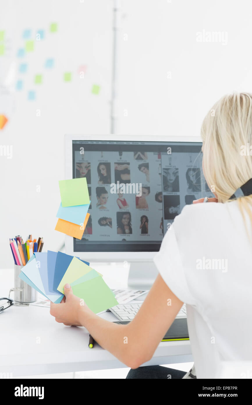 Rear view of casual woman using computer in office Stock Photo - Alamy