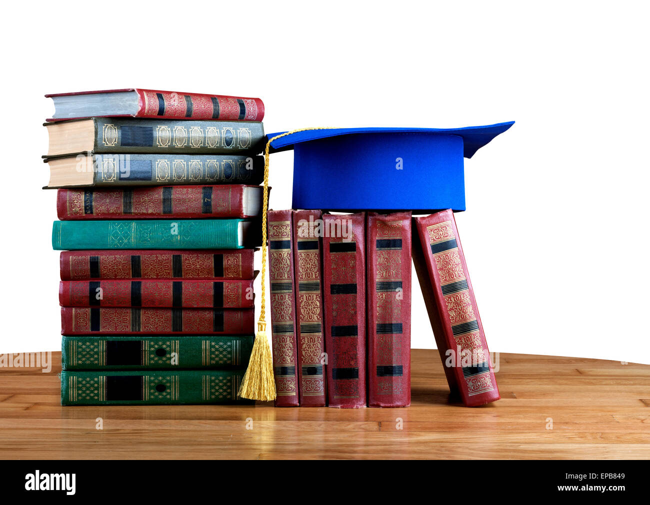 Graduation mortarboard on top of stack of books on white isolated ...