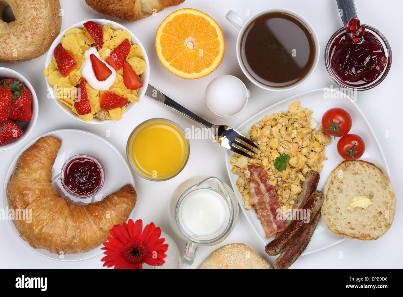 Frühstück mit Müsli, Kaffee, Rührei, Früchten und Brötchen von oben ...