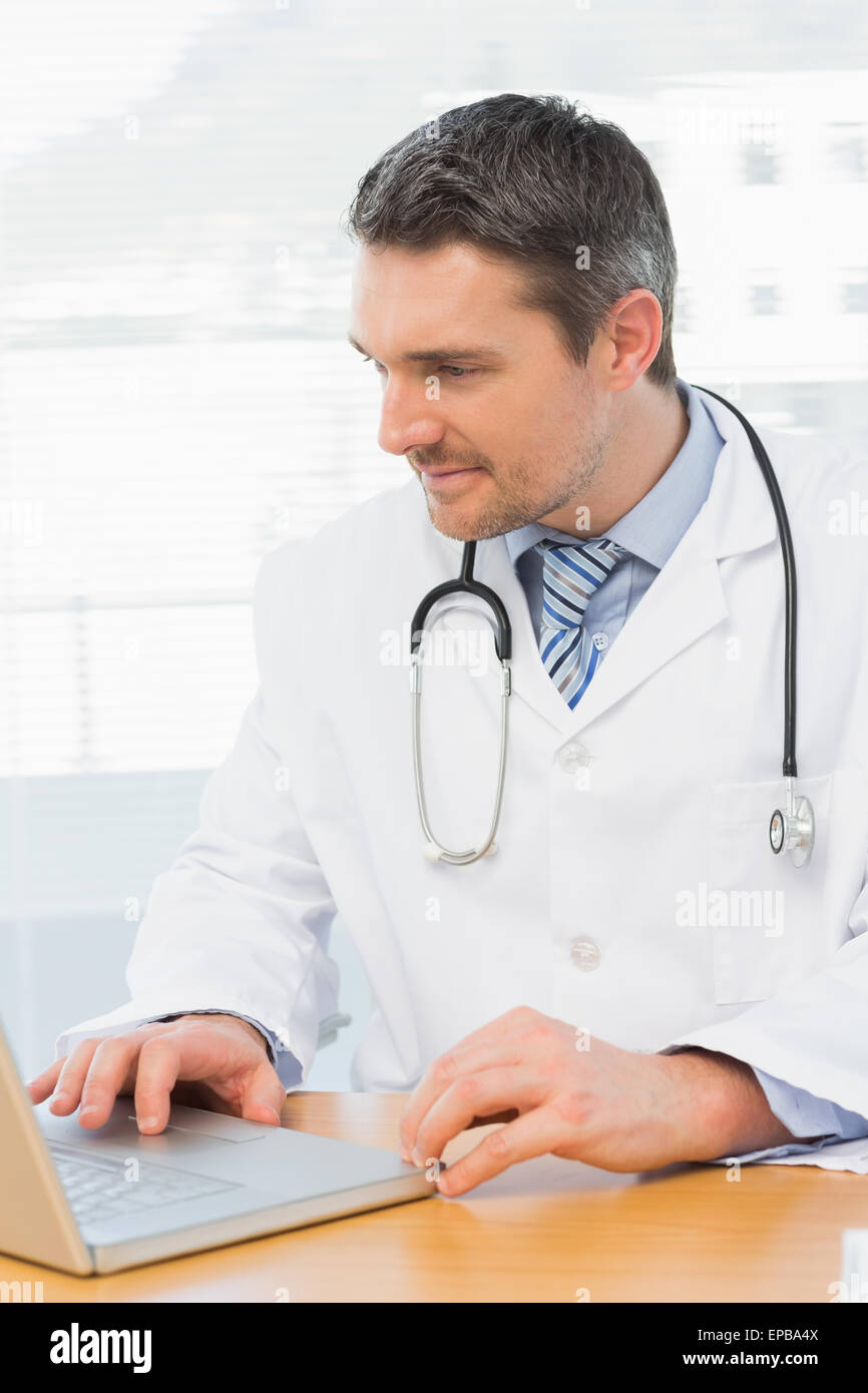 Doctor working on laptop in medical office Stock Photo