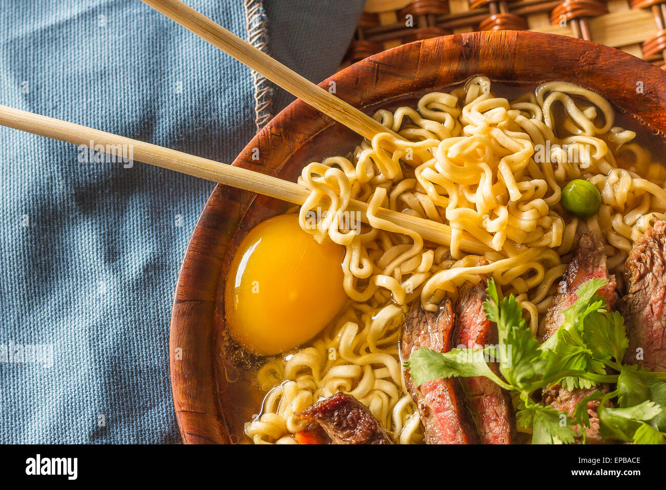 Beef ramen served Asian style. Raw egg cooks in steaming hot savory broth Stock Photo