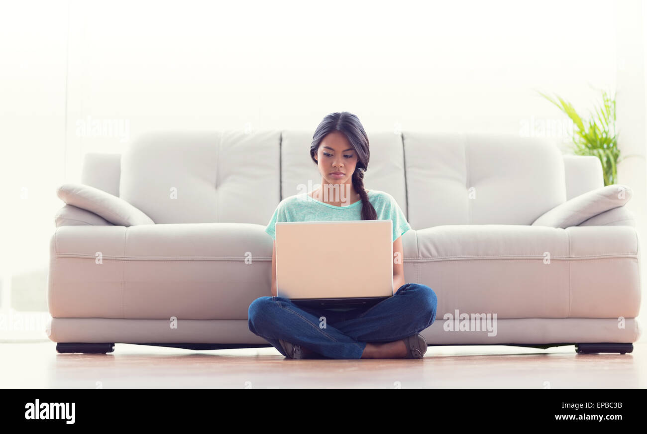 Pretty girl sitting on floor using her laptop Stock Photo - Alamy