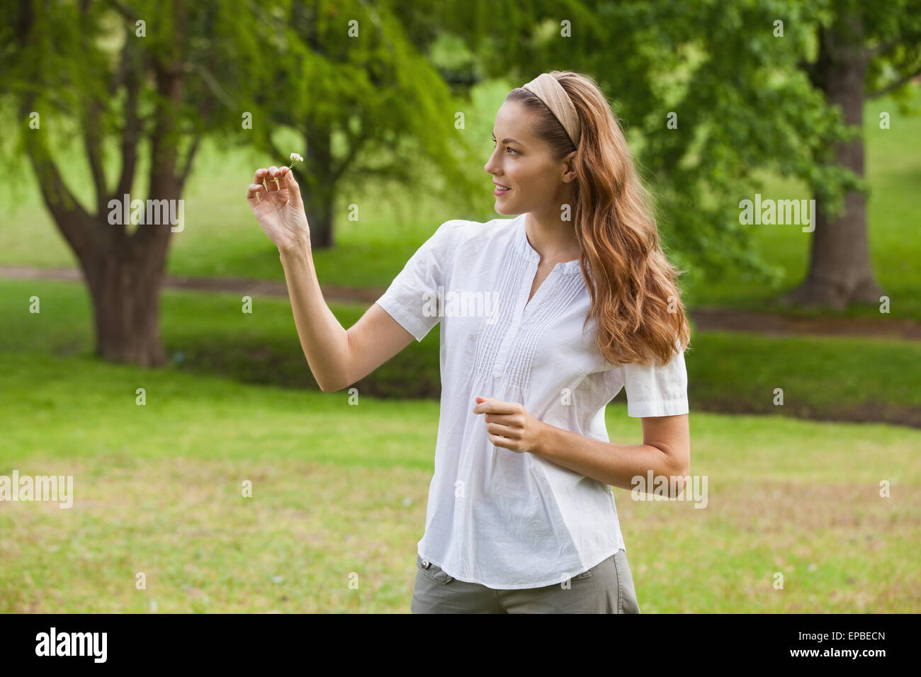 Woman holding a flower at park Stock Photo - Alamy