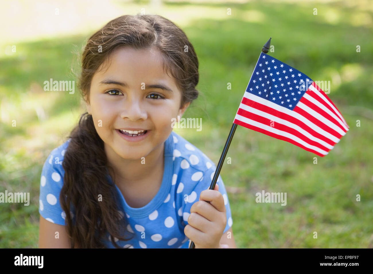 Young girl holding the American flag at park Stock Photo - Alamy