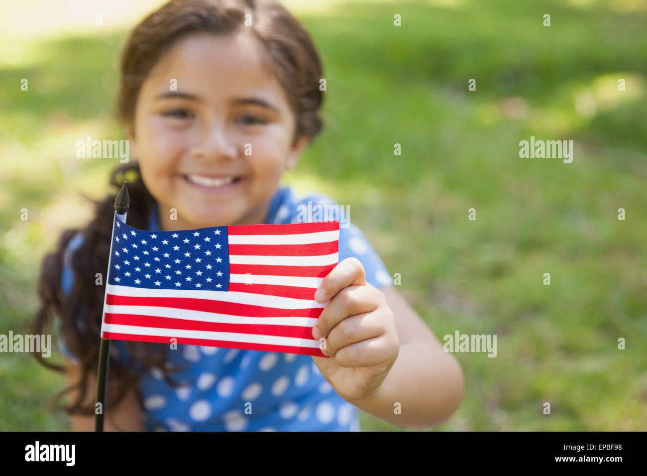 Young girl holding the American flag at park Stock Photo - Alamy