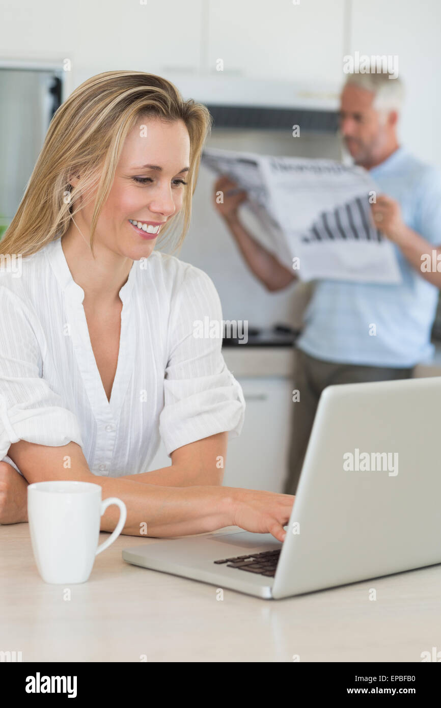 Using Computer With Partner Smiling woman using laptop with partner standing with the paper Stock ...