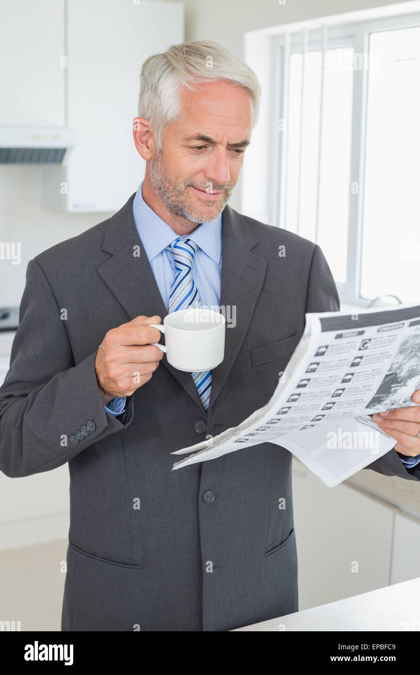 Smiling businessman having coffee in the morning before work Stock