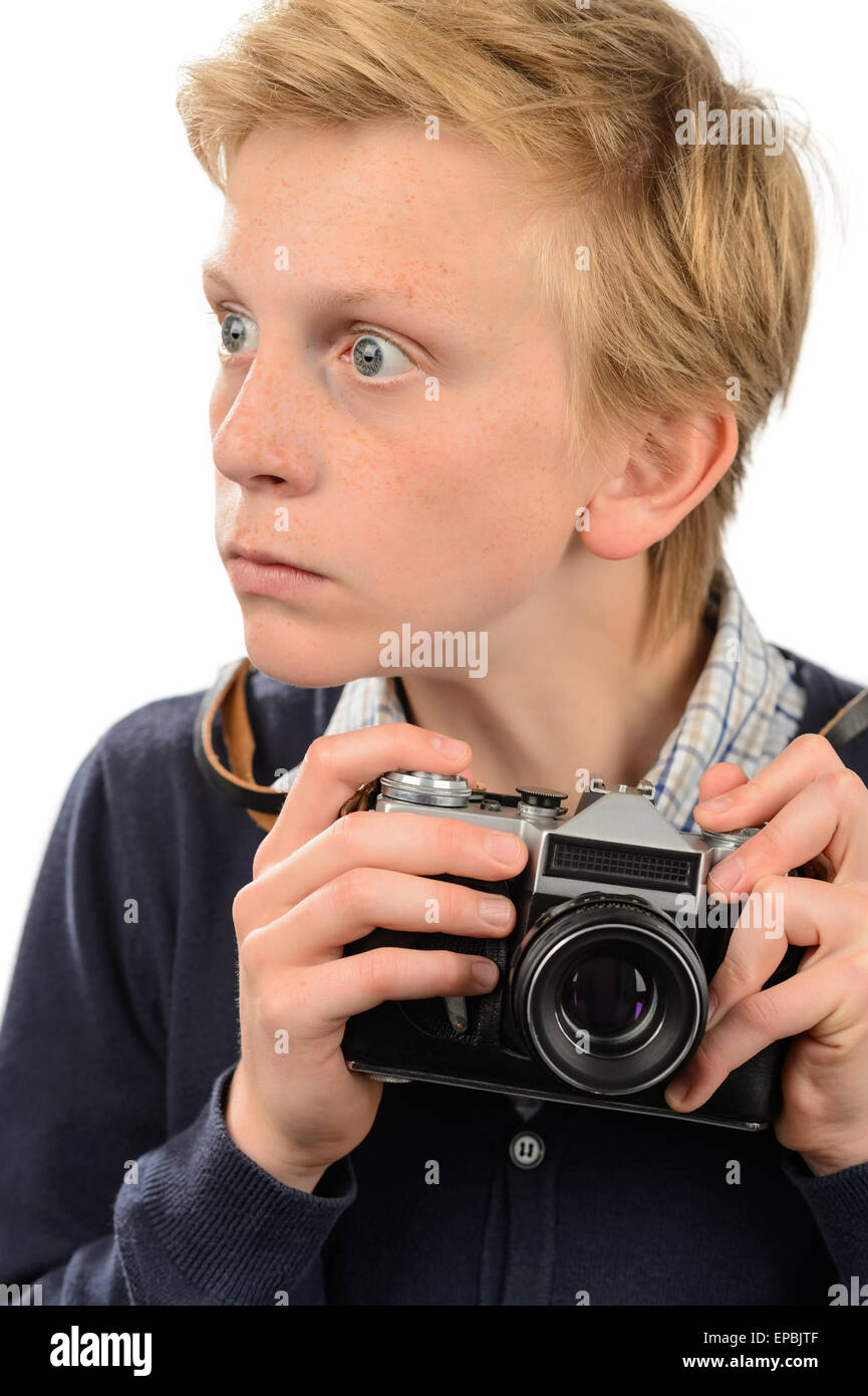 Shocked teenage boy holding retro camera Stock Photo