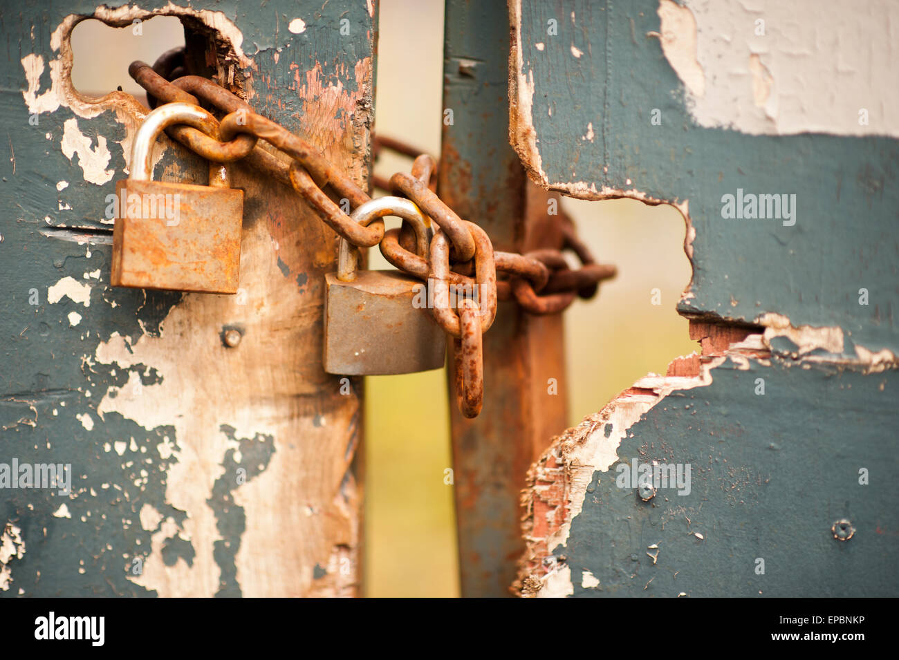 Rusty pad lock and chain locking the entrance to scrap yard, Old