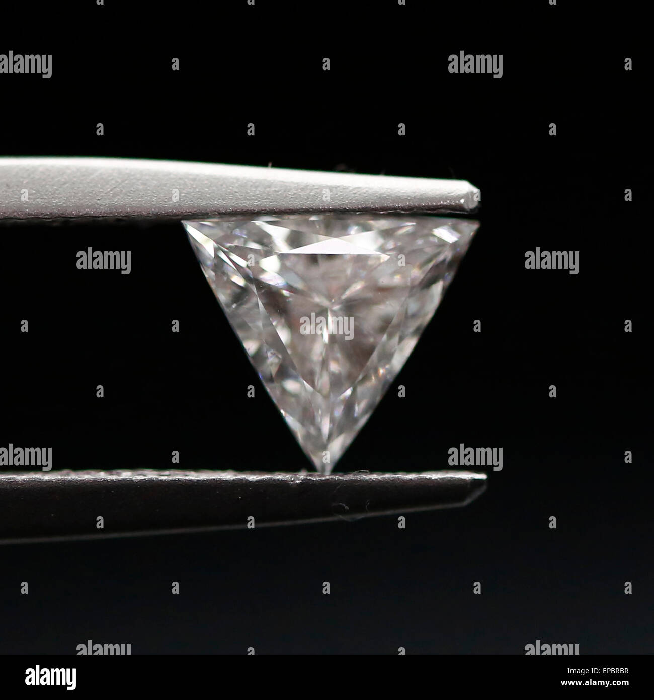 Trillion Triangle loose polished diamond in tweezers Stock Photo