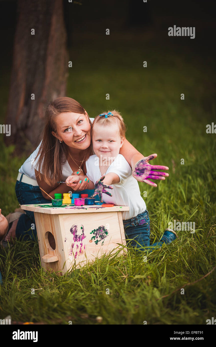 Happy family with nesting box and paints Stock Photo