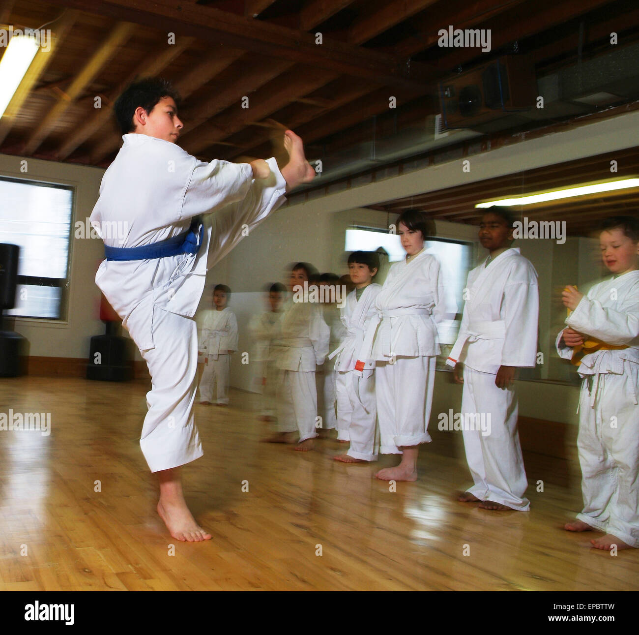 7-year-old boy demonstrating flying karate kick Stock Photo