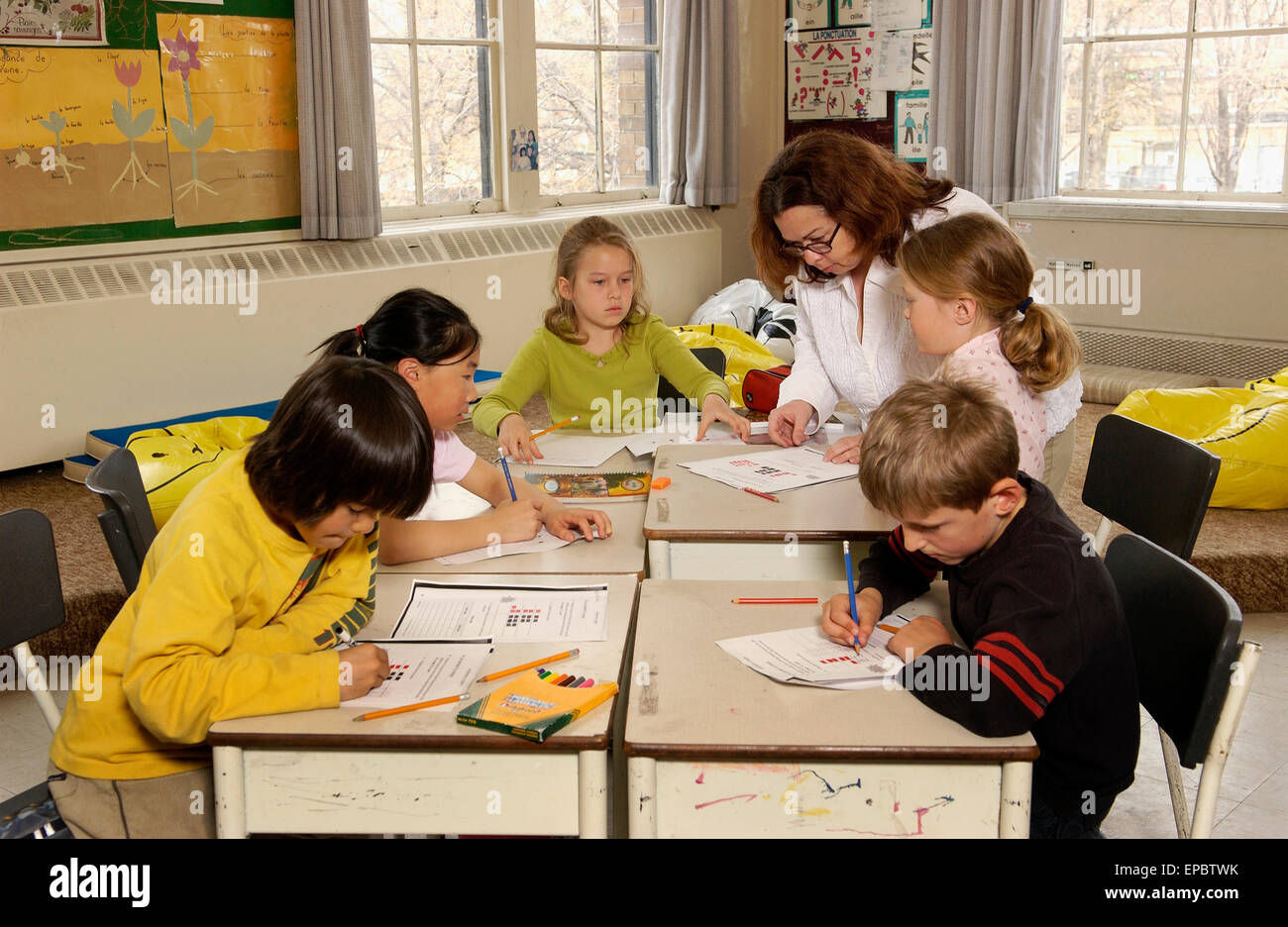 Grade 3 students working in class with teacher Stock Photo
