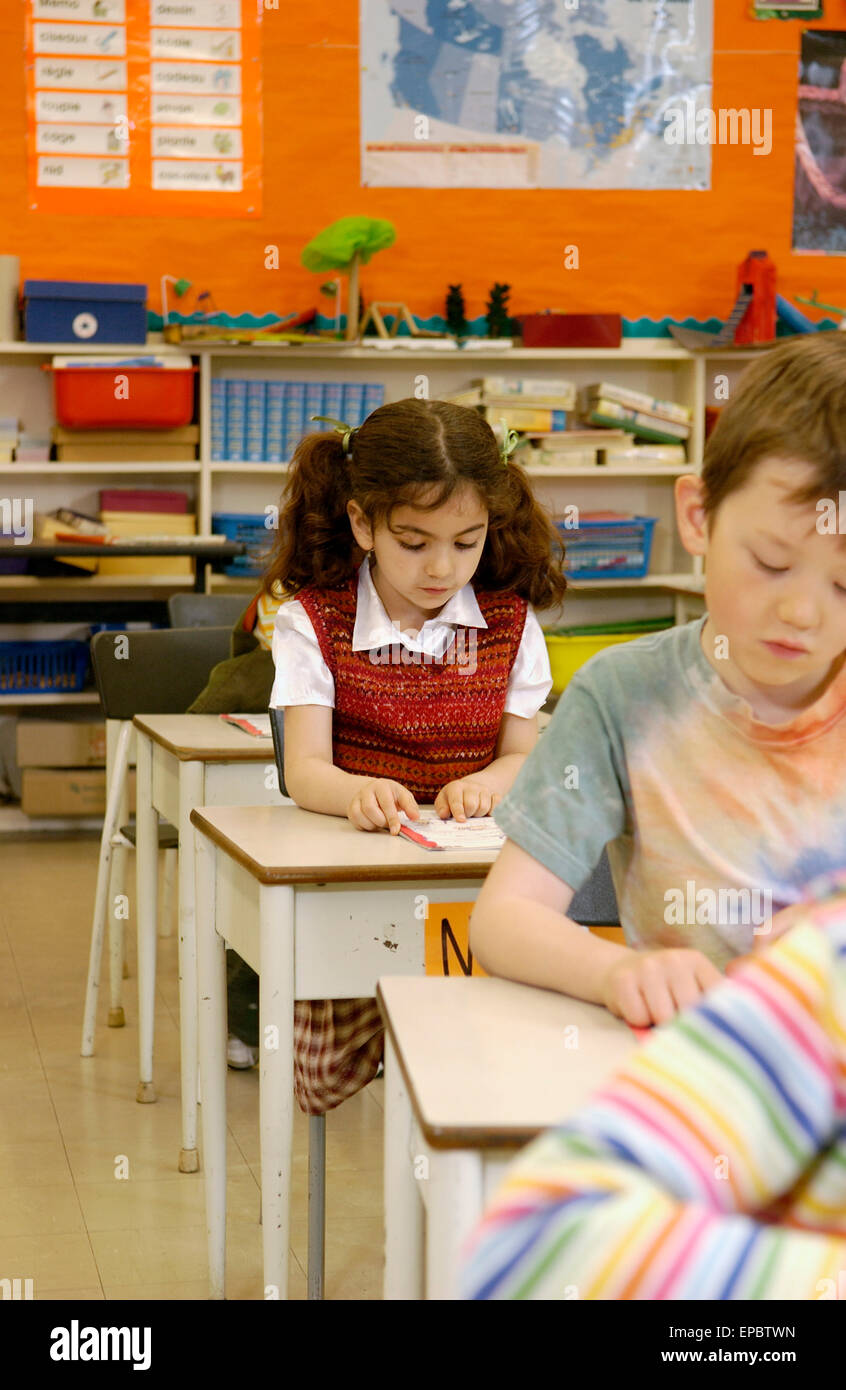 Grade 2 students working at their desks in a classroom Stock Photo