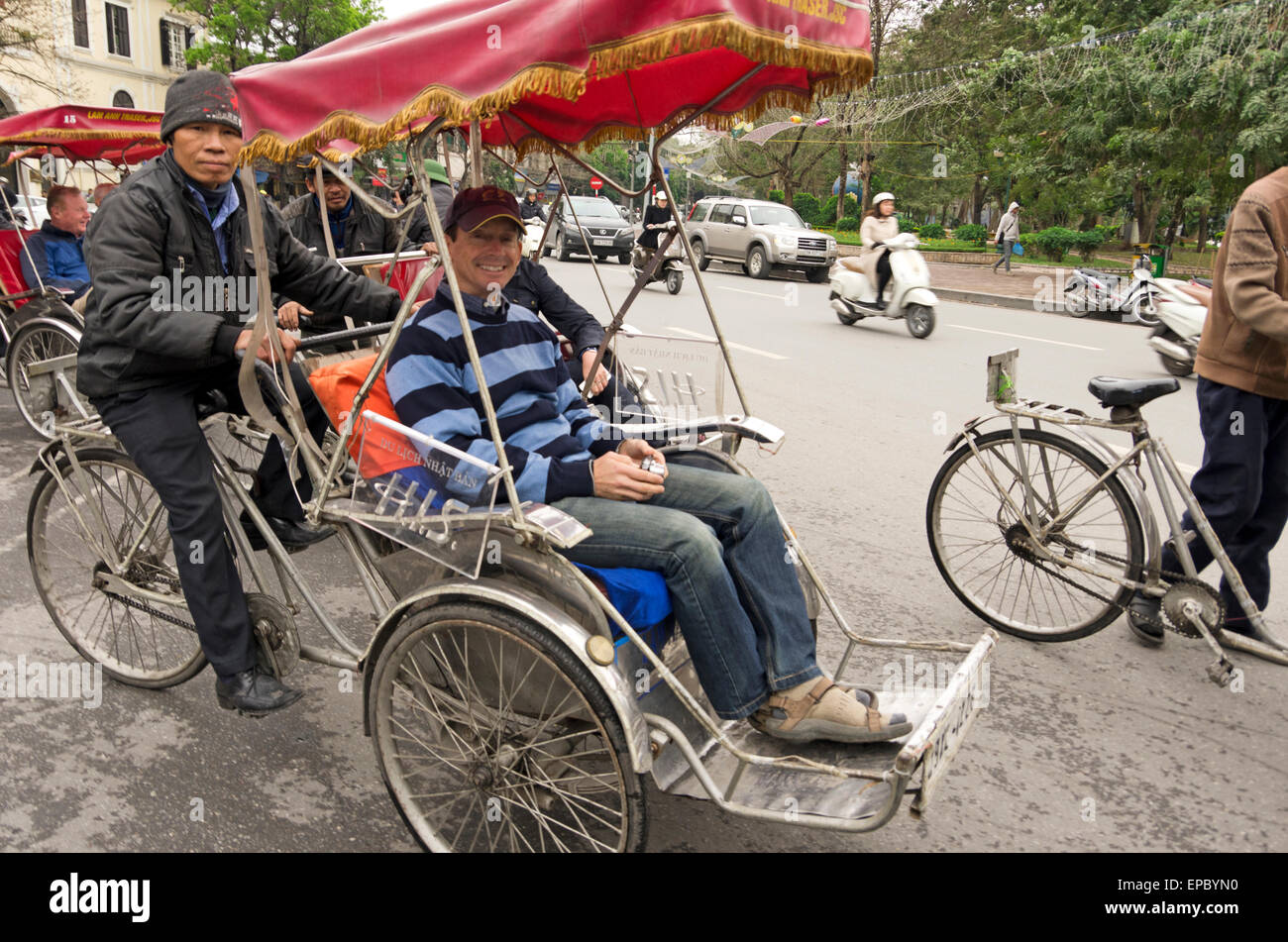 Man is taken for a ride on bicycle cart through old quarter of Hanoi
