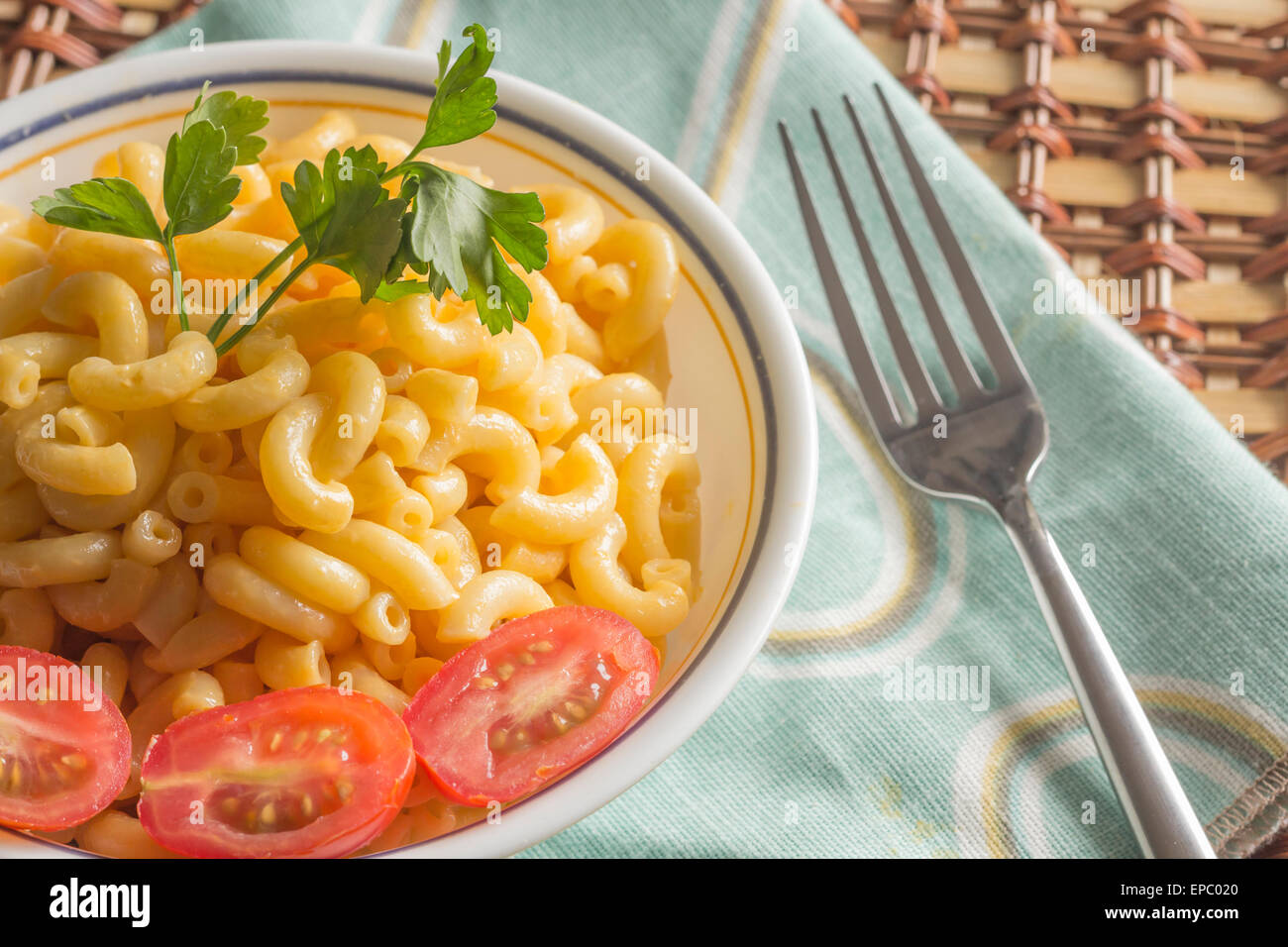Delicious macaroni and cheddar cheese with fresh sliced grape tomatoes