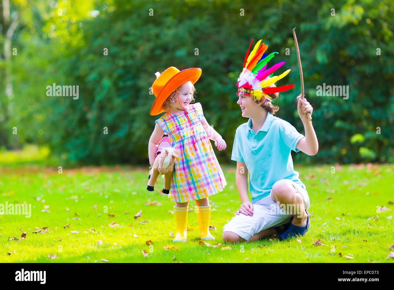 Two happy kids, laughing boy dressed as native American with colorful