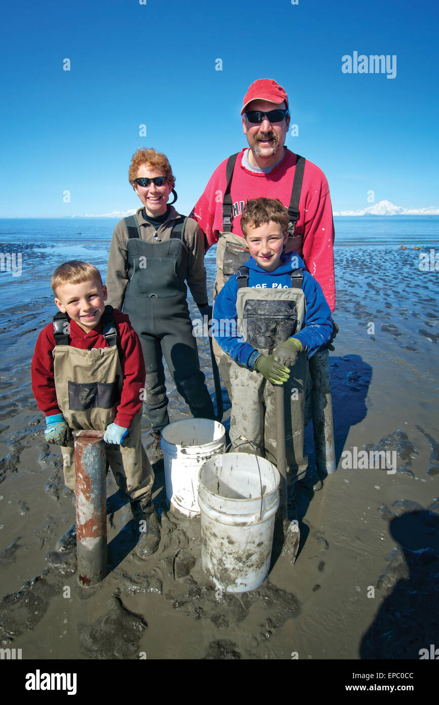Family poses with buckets and tools for clamming during a minus tide at