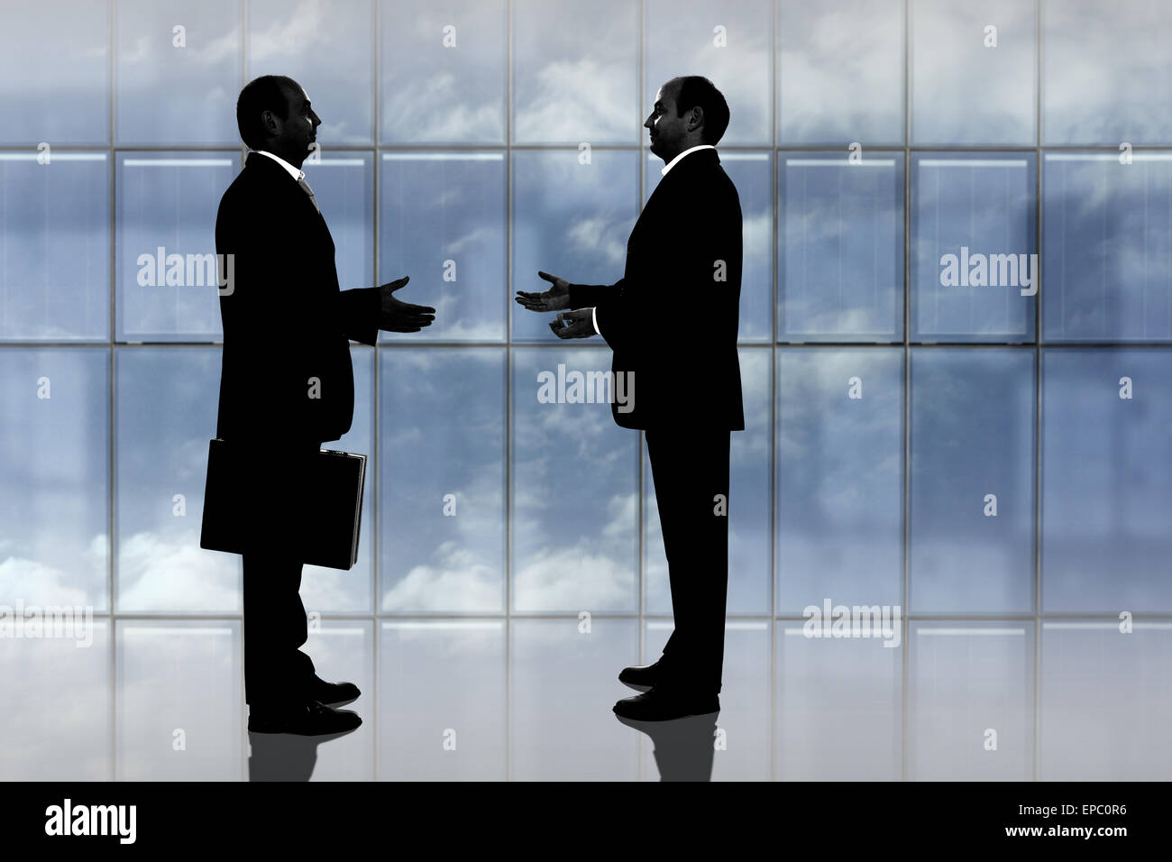 Businessmen silhouette negotiating a business deal Stock Photo