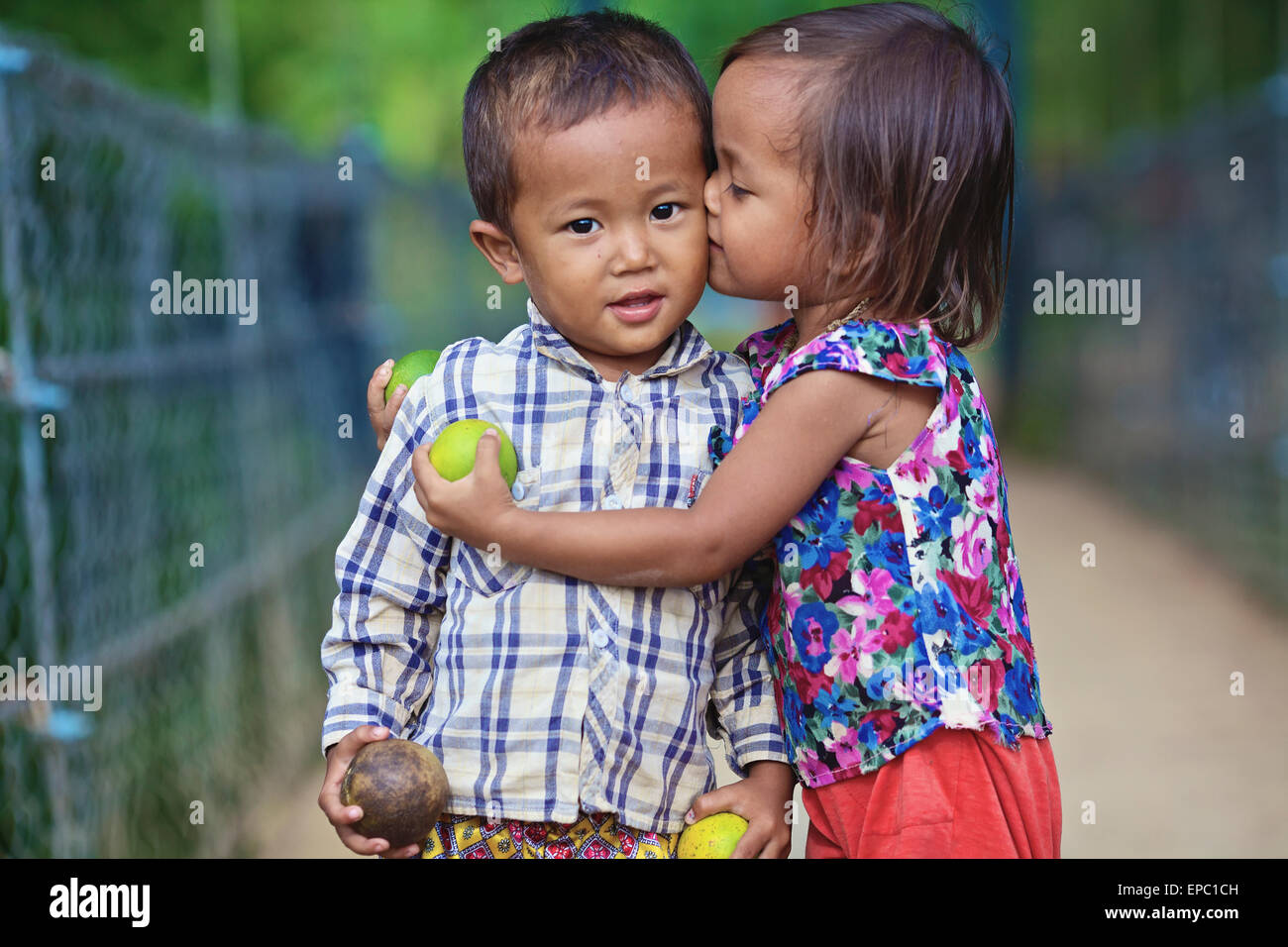 Young girl kissing a young boy; Battambang, Cambodia Stock Photo