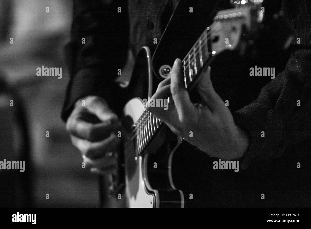 Guitar player performing with Fender Telecaster guitar in black & white - detail on guitar neck and hands with no face Stock Photo