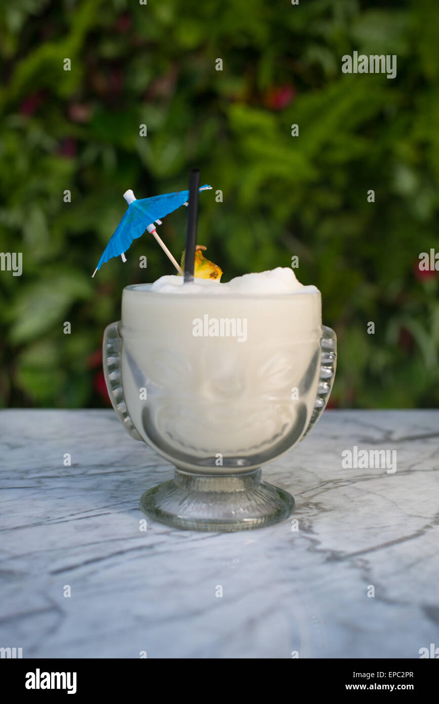 A pina colada cocktail with umbrella and pineapple slice garnish Stock