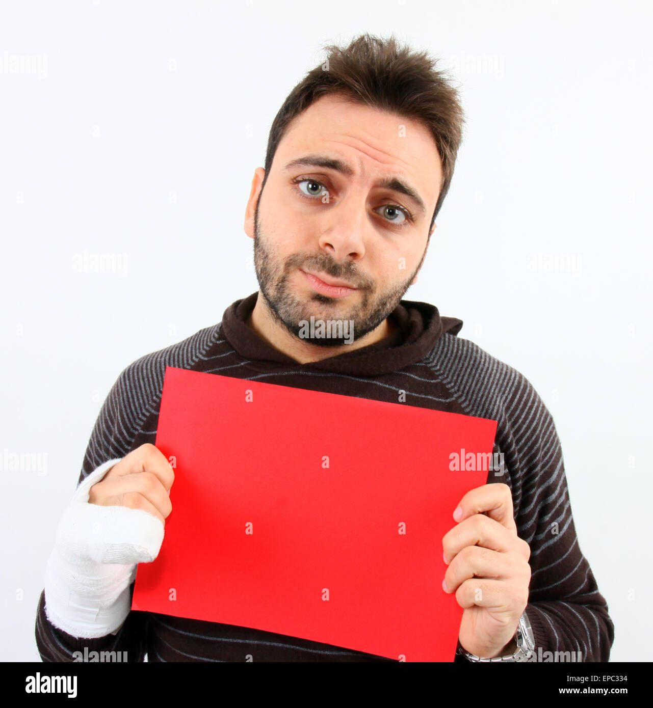 Young man with a fracture of the fifth metacarpal while keeps red billboard Stock Photo