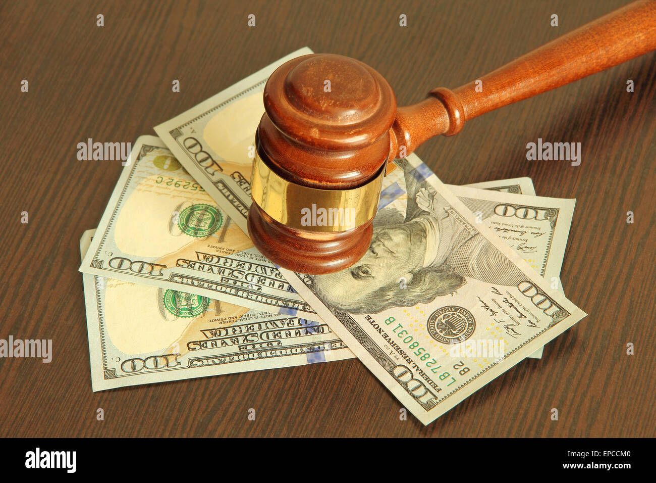 Judge gavel and dollar banknotes on wooden table taken closeup. Stock Photo