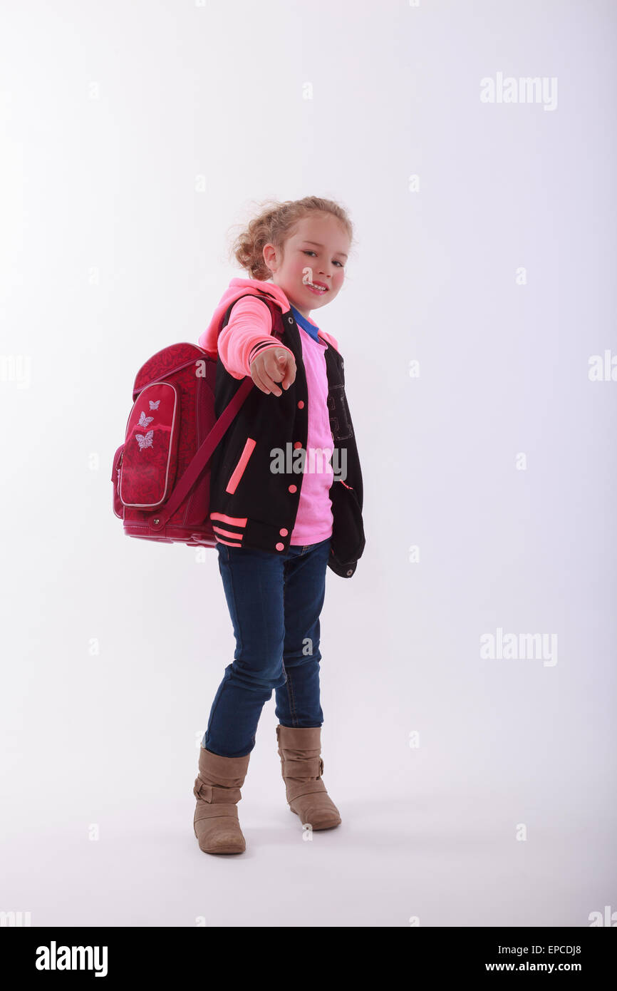 Girl with school bag points with the finger in the camera Stock Photo