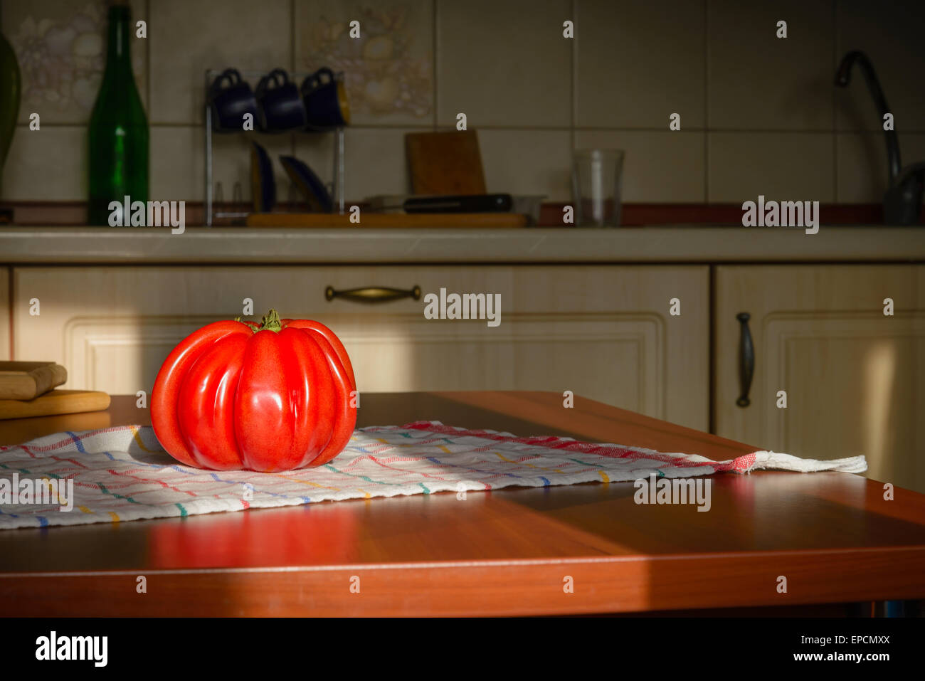 Beef Heart tomato, Olena Ukraina, on the kitchen table illuminated by the morning sunlight Stock Photo