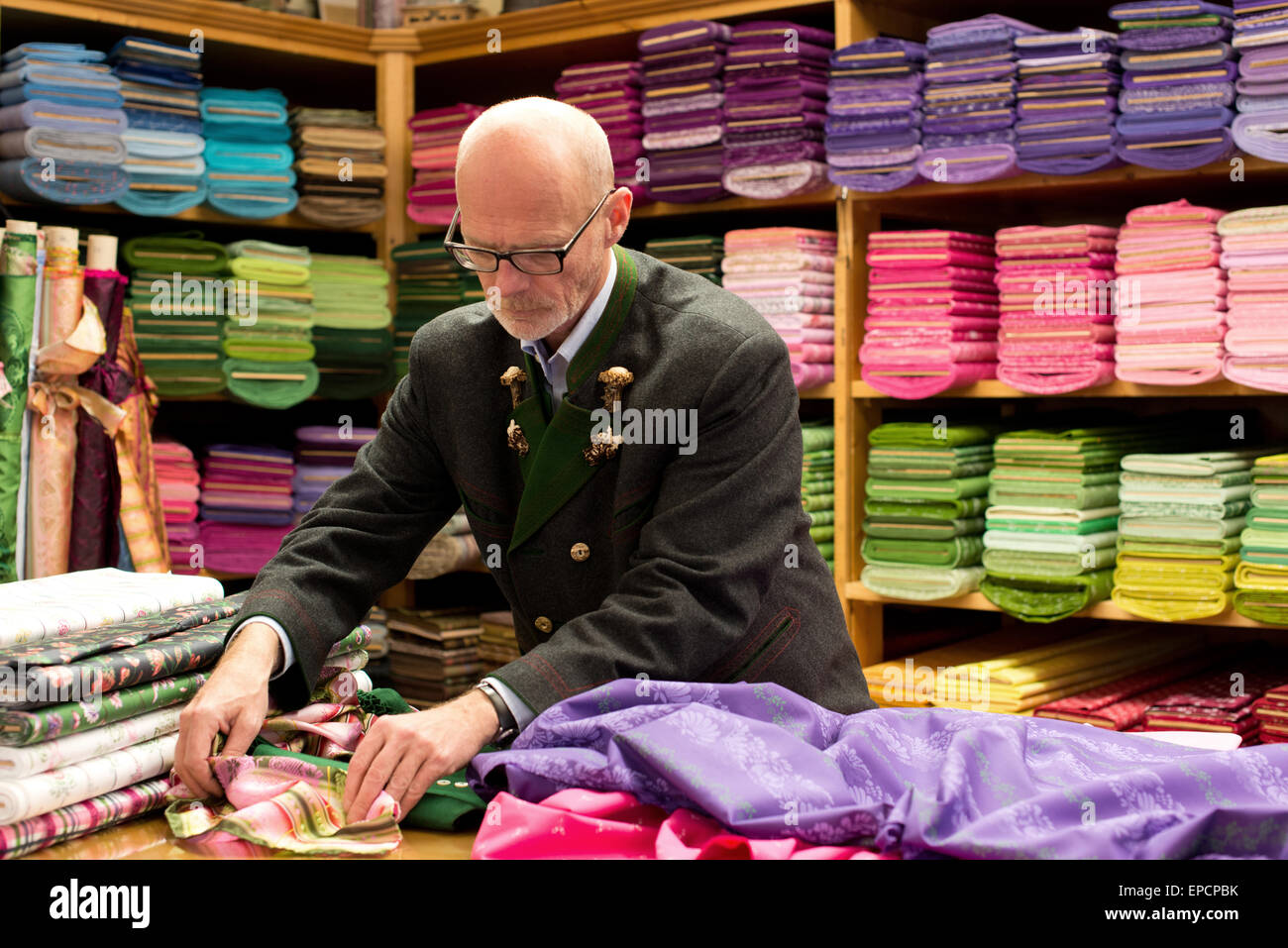 Peter Veigl surrounded by dirndl-fabrics in his shop Ausseer G'wand in Bad Aussee, Styria, Austria Stock Photo