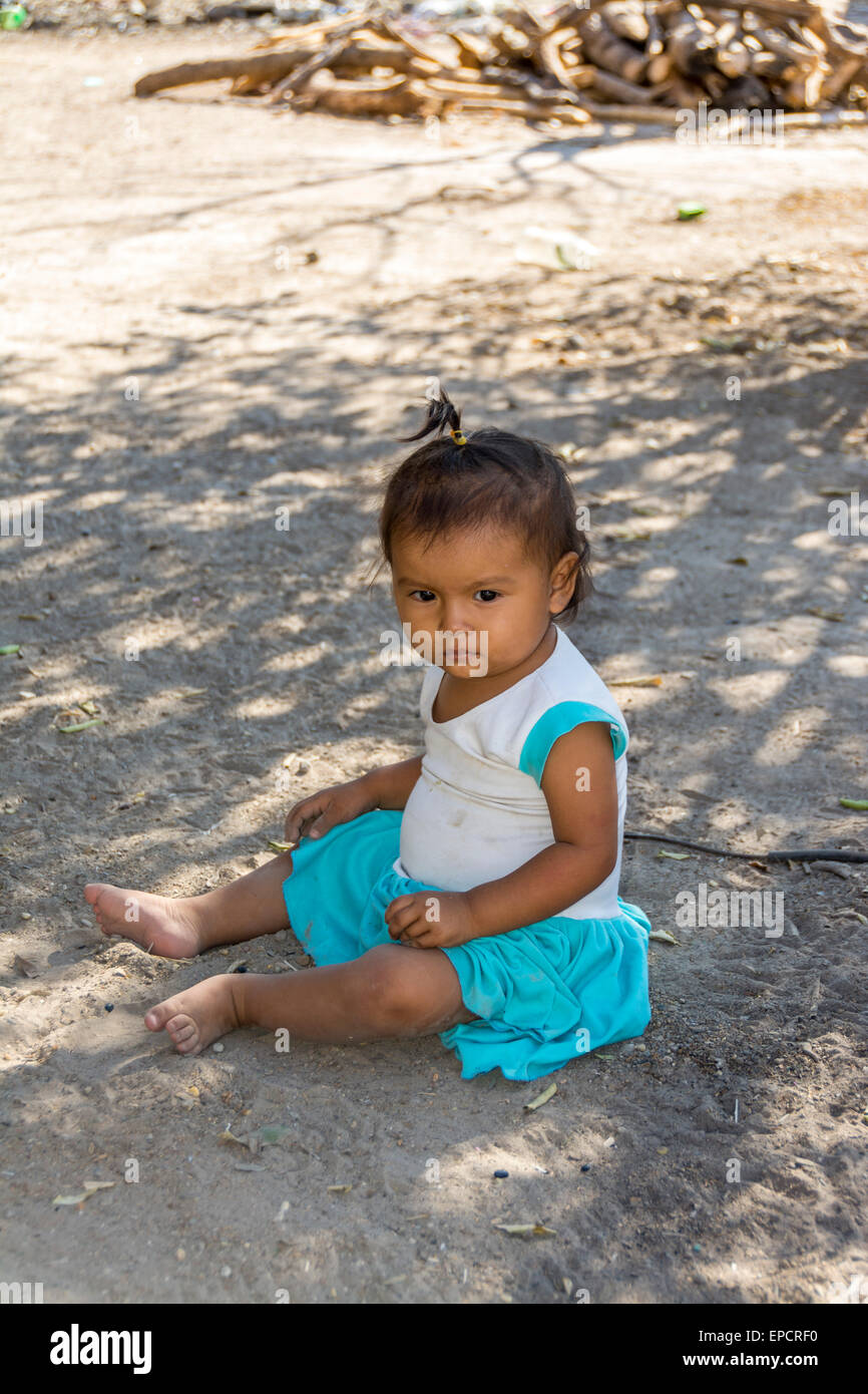 Young Guatemalan girl sitting on the ground in a remote farming village in southern Guatemala Stock Photo