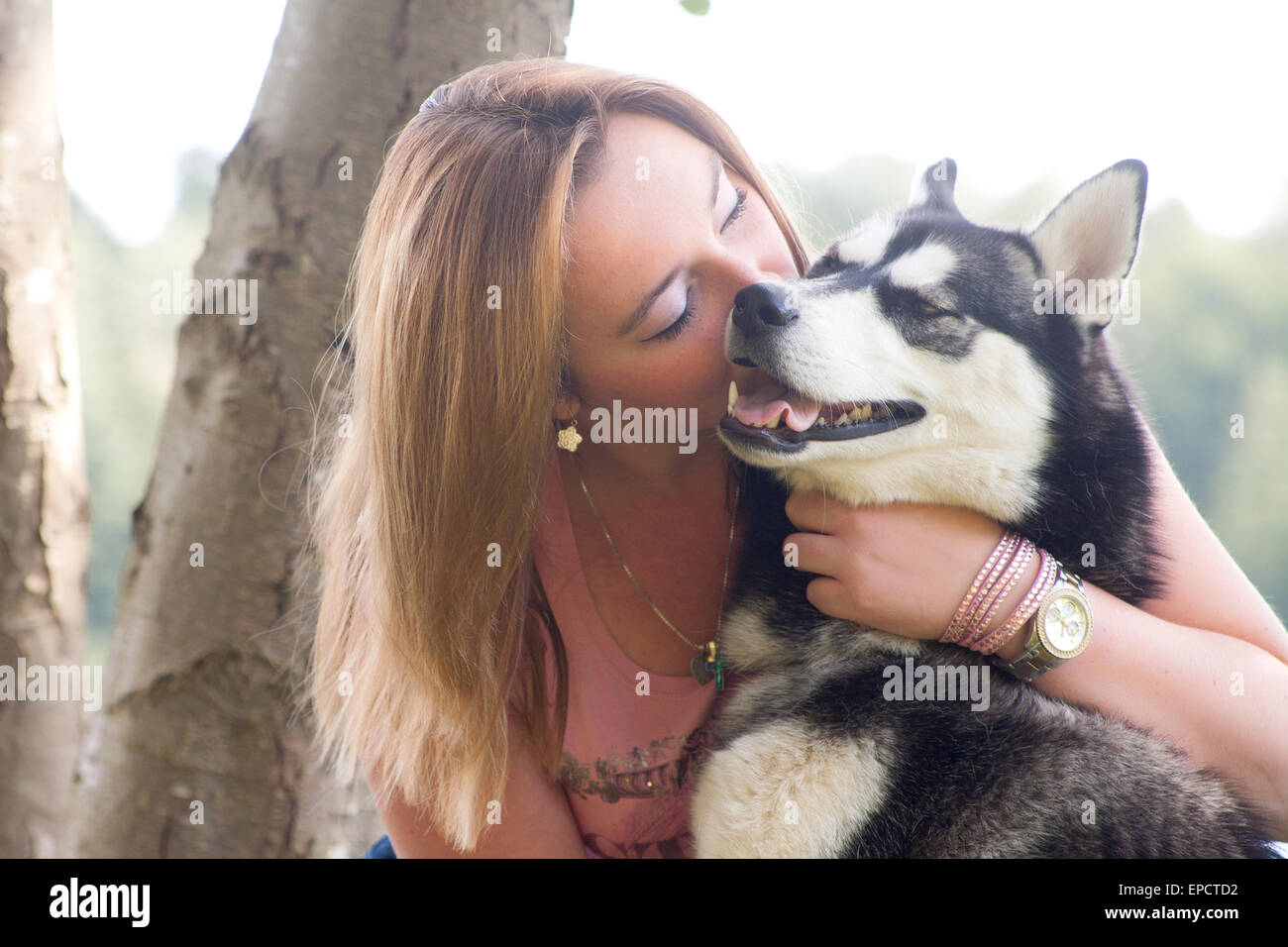 Young woman and her husky in the forest Stock Photo