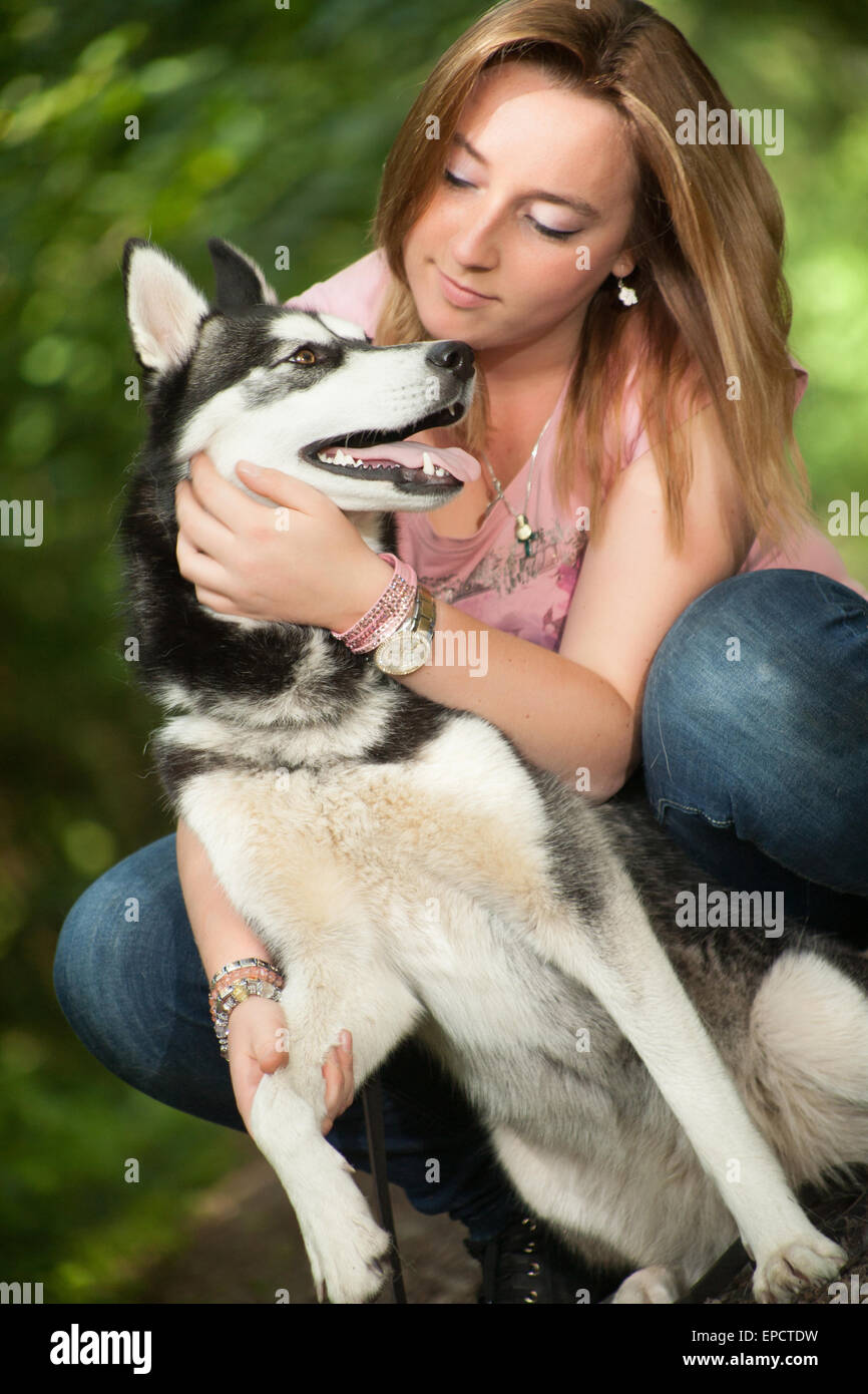 Young woman and her husky in the forest Stock Photo