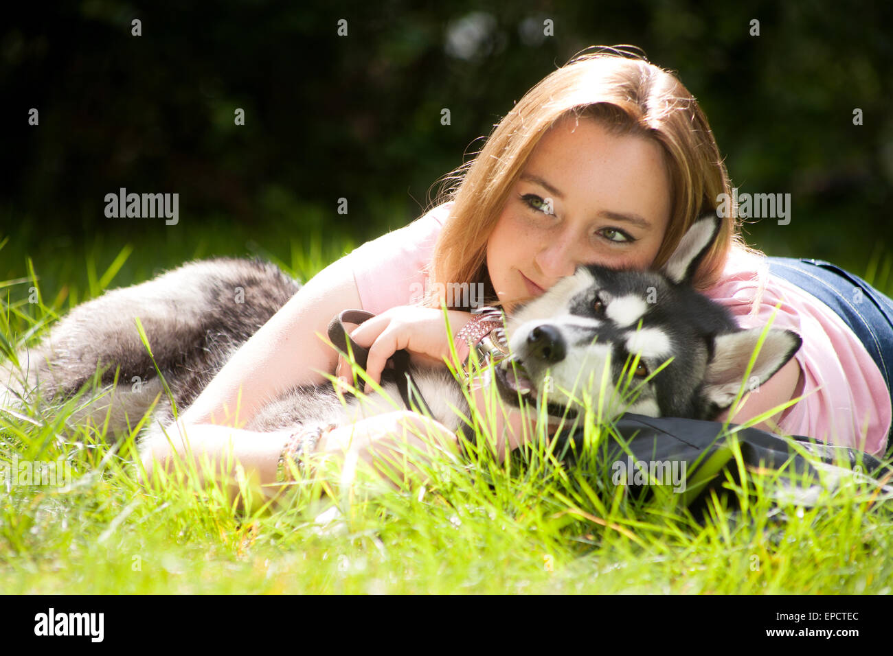 Young woman and her husky in the forest Stock Photo