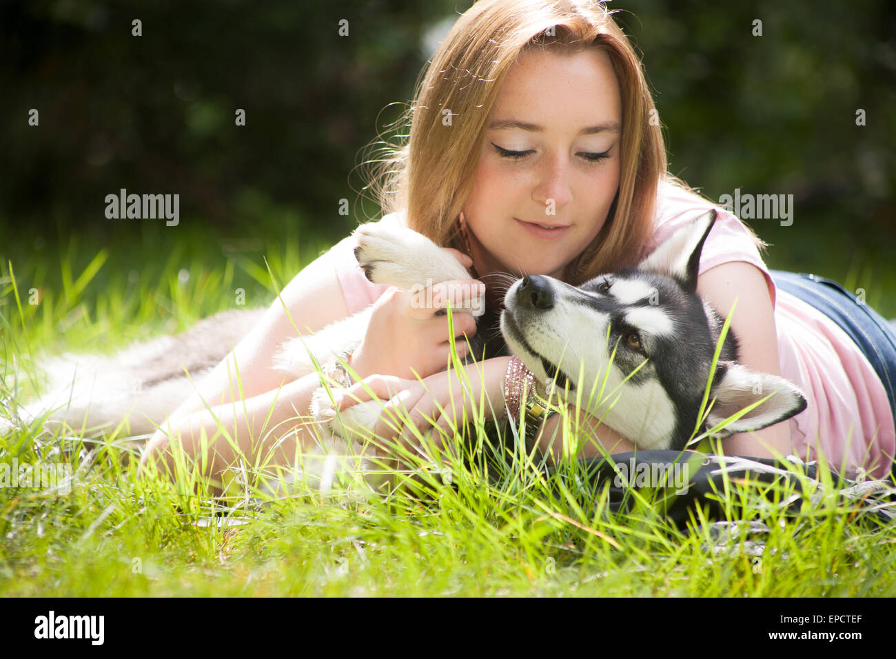 Young woman and her husky in the forest Stock Photo