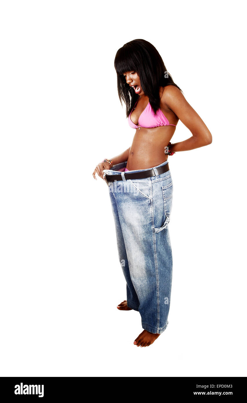 A pretty African American woman in a pink bikini put on her old jeans and find out she lost a lot of weight, for white Stock Photo