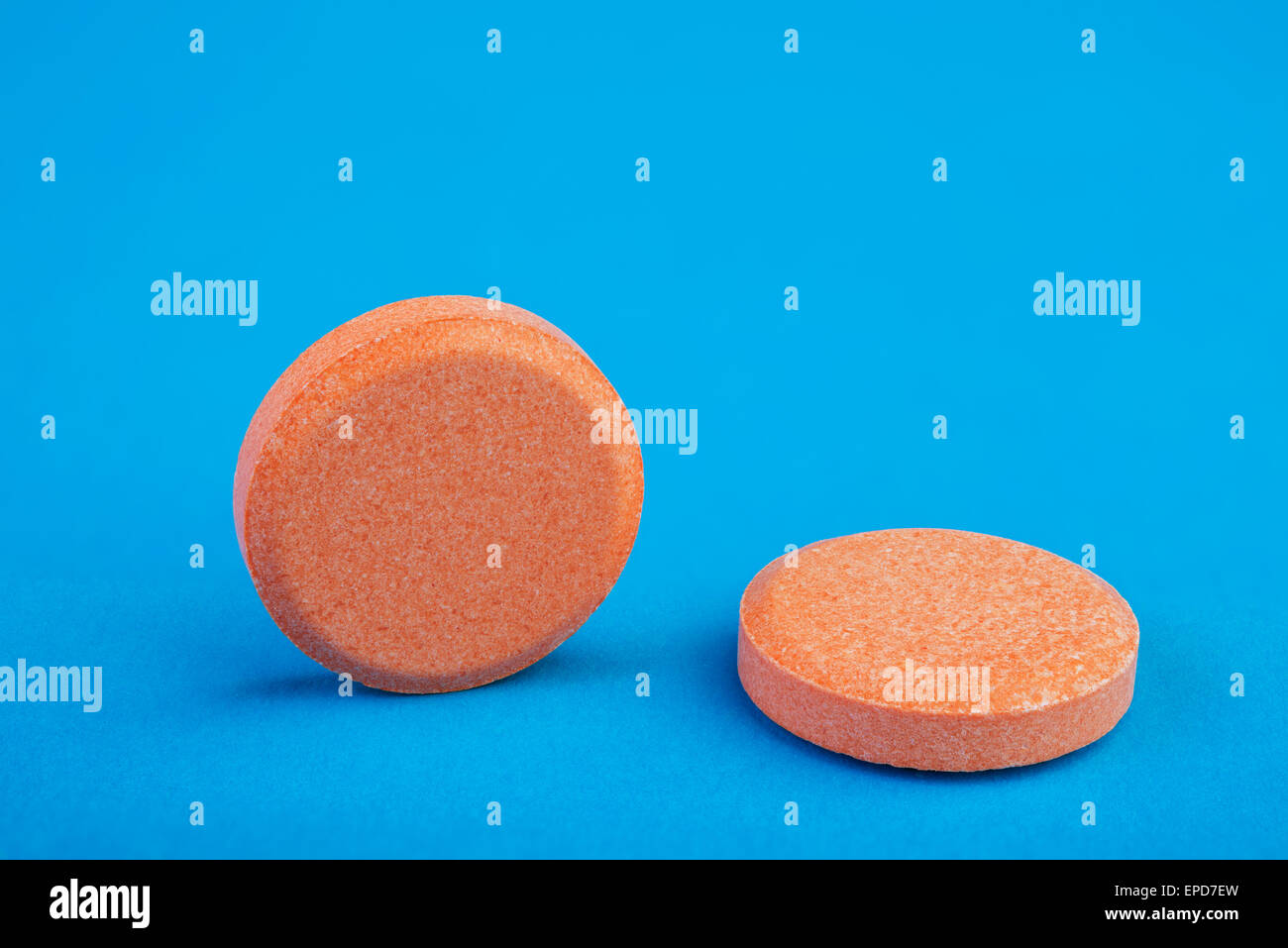 two orange tablets on a blue background Stock Photo