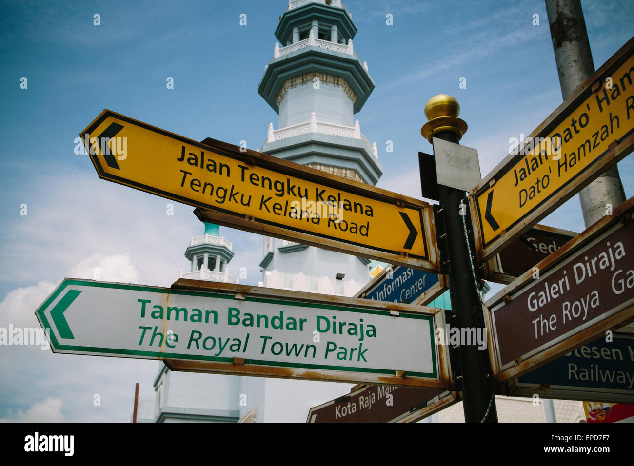 Signpost in Klang, Malaysia, in Malay and English, with a temple in the background. Stock Photo