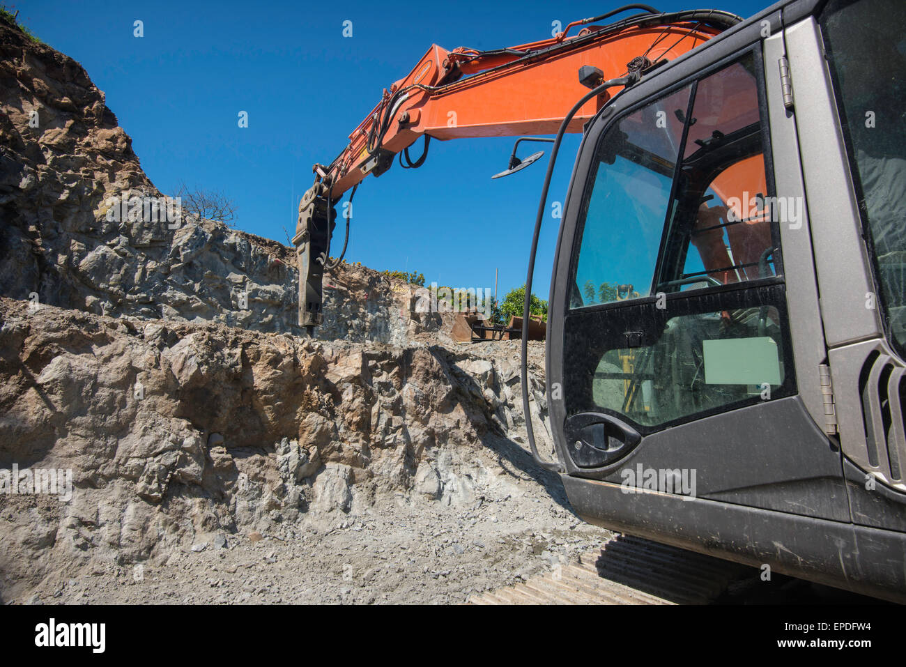 Excavator with hydraulic hammer, in a quarry. Stock Photo