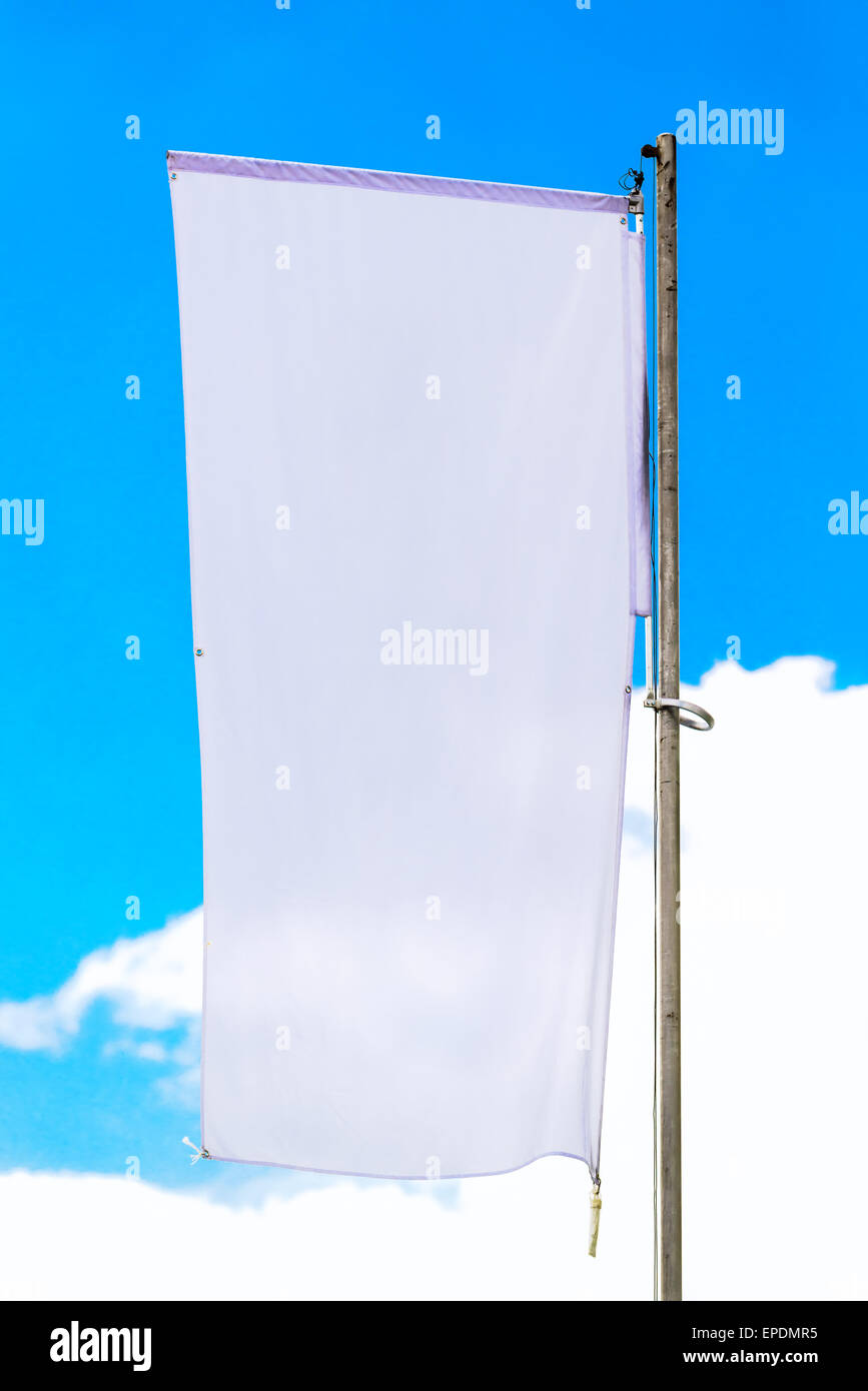 Blank White Waving Banner Flag on Pole against Blue Sky, Copy Space Ready for Mock up Design. Stock Photo