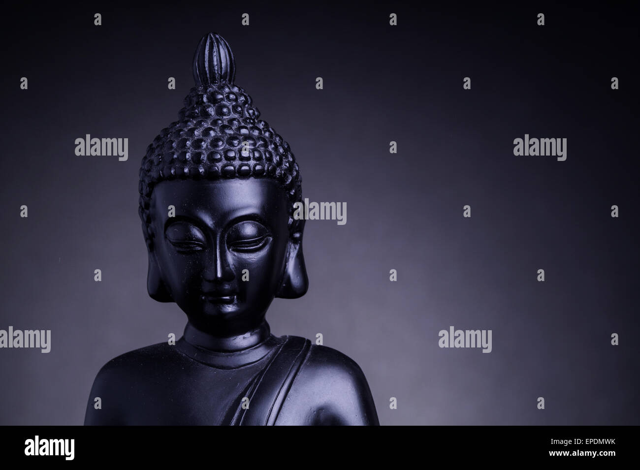 Statue of the Buddah with grey backlight Stock Photo