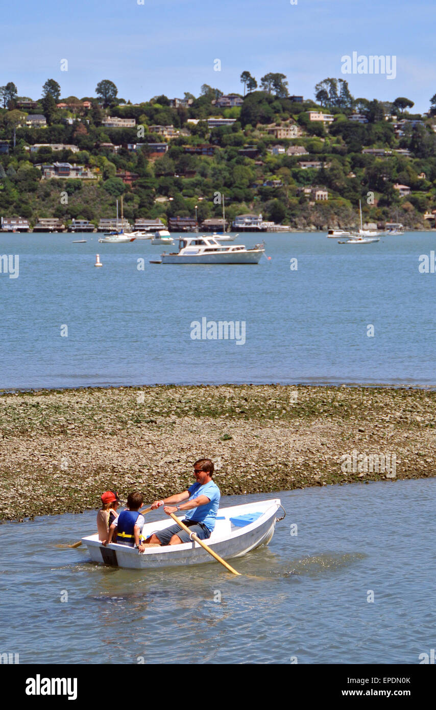 father takes kids for a ride in a rowboat at the Sausalito Cruising Yacht club in Marin County Stock Photo