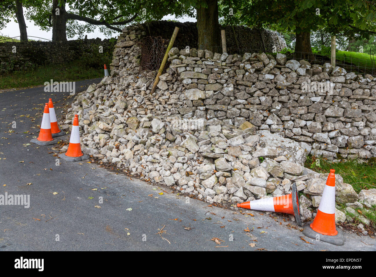 UK, England, Yorkshire Dales.  Collapsed Stone Wall and Traffic Alert Cones, Kettlewell Village. Stock Photo