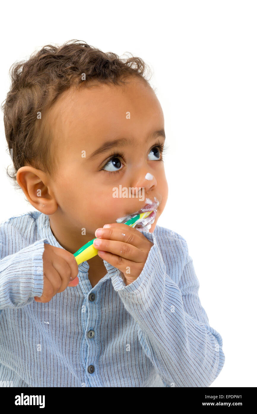 Smiling 18th month old African toddler boy brushing his teeth Stock