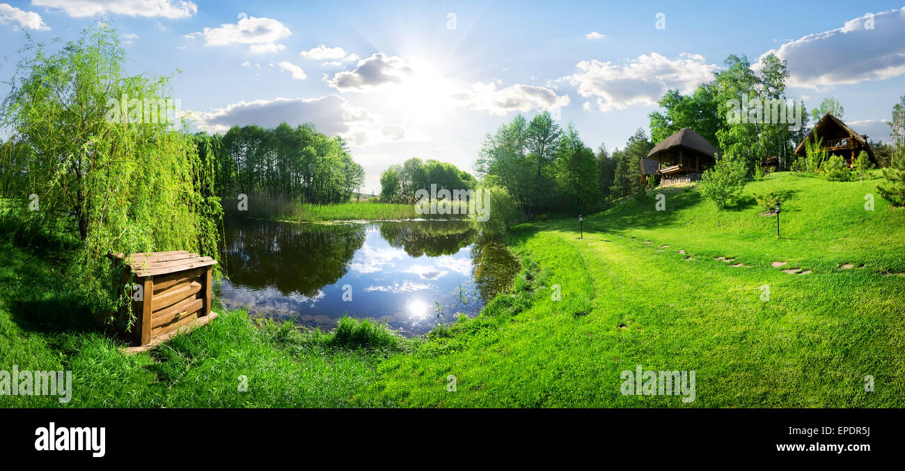 Wooden house near river at sunny day Stock Photo Alamy