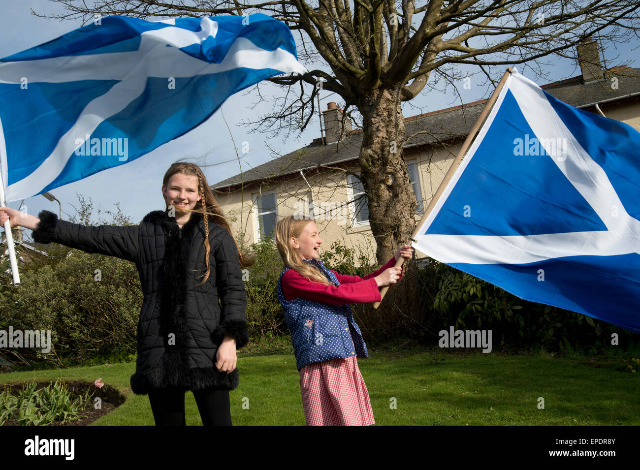 Scotland. Two girls with flags about to join an eve of election calvacade around the town by the SNP (Scottish National Party). Stock Photo