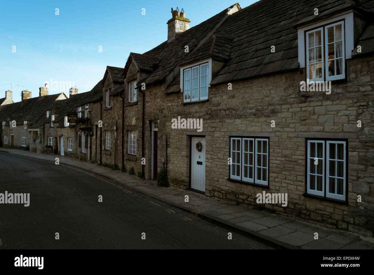 Historic houses in Corfe Castle village in Dorset with a row of very old stone properties Stock
