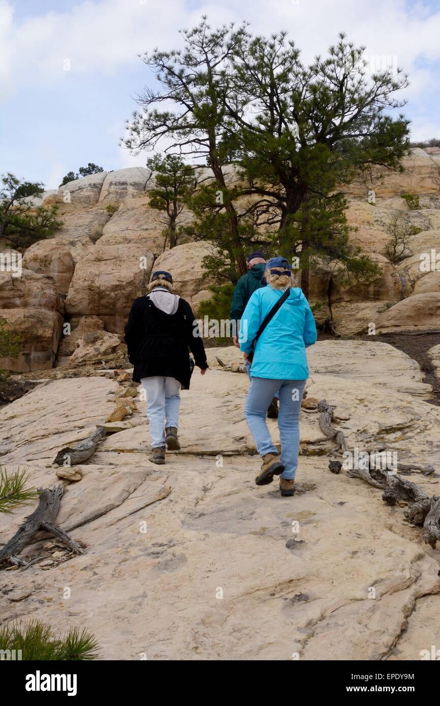 Three Seniors following trail to top at El Morro National Monument New Mexico - USA Stock Photo